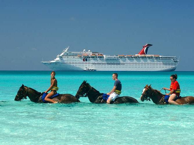 three horseback riders and a Carnival Cruise liner