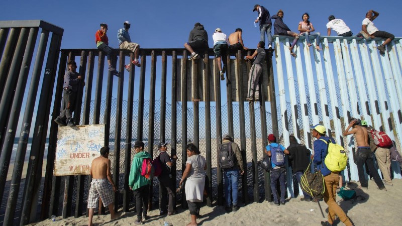 migrants climbing border fence