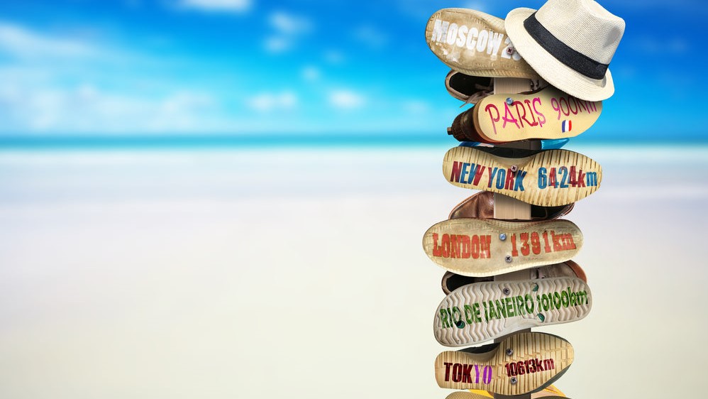 hats and slippers on a pole at the beach