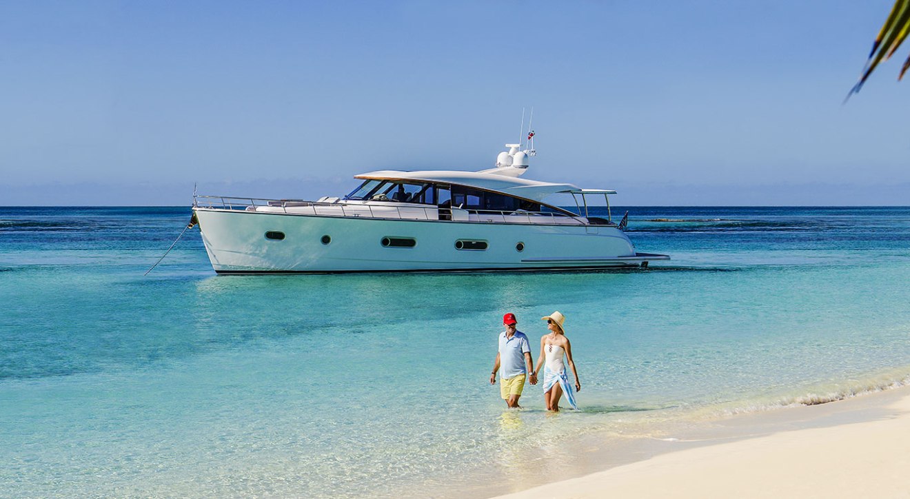 Belize, two people on the beach and a yacht in the horizon