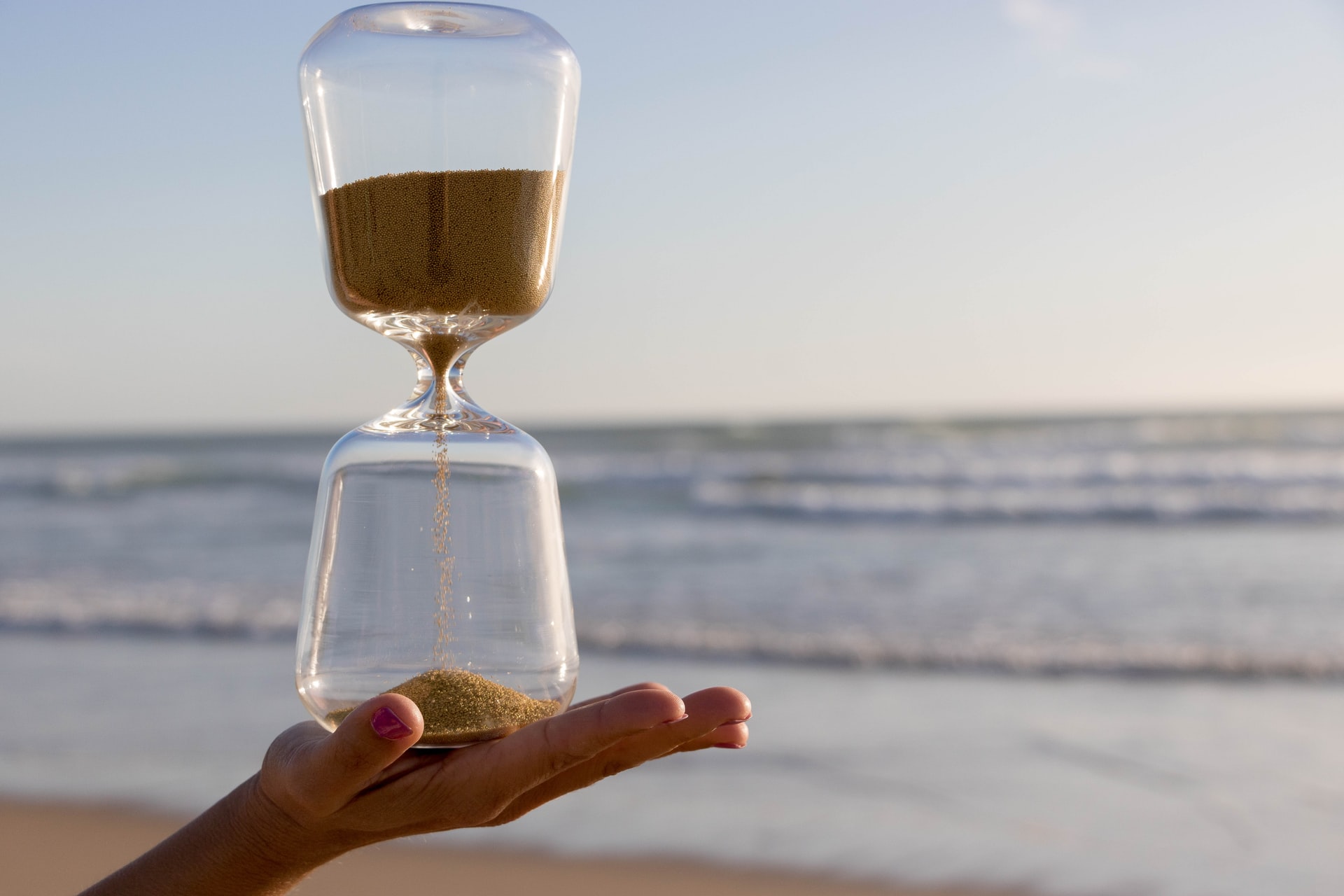 hourglass on a hand at the beach