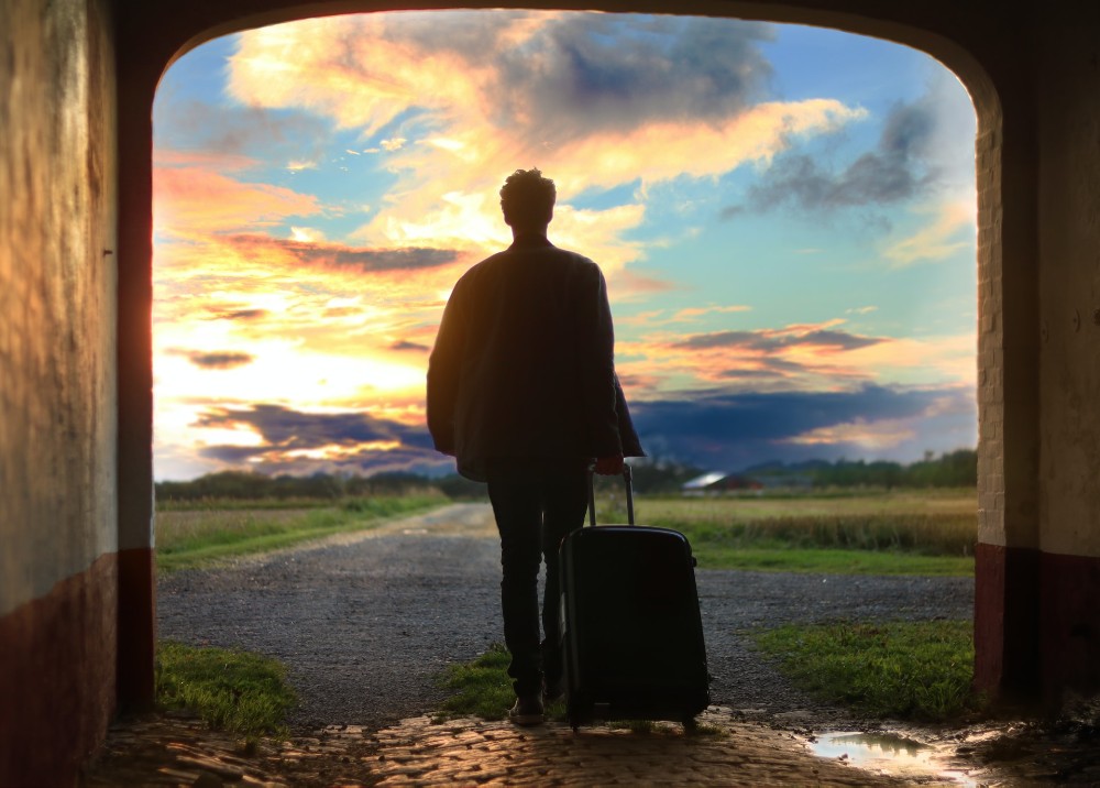 man with a suitcase under an arch