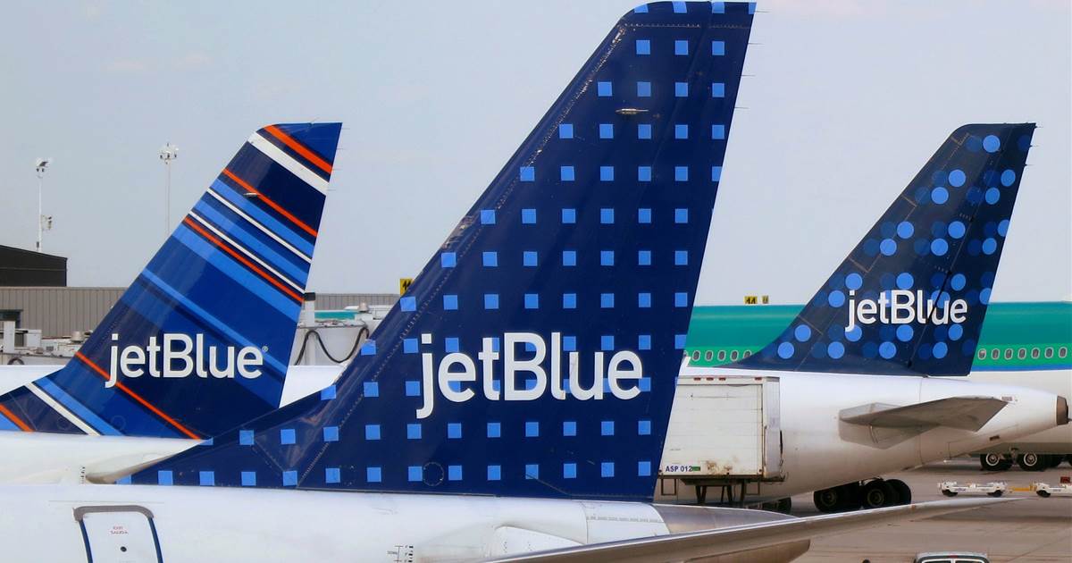 three JetBlue aircraft tails at an airport