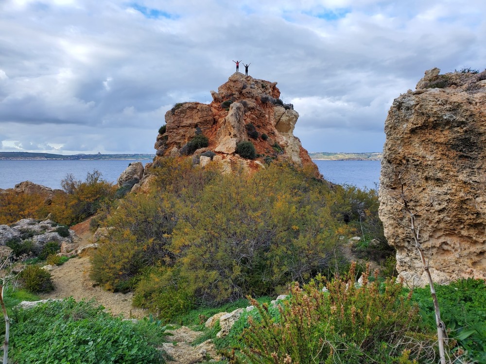 Malta, two people standing on a rock in the distance