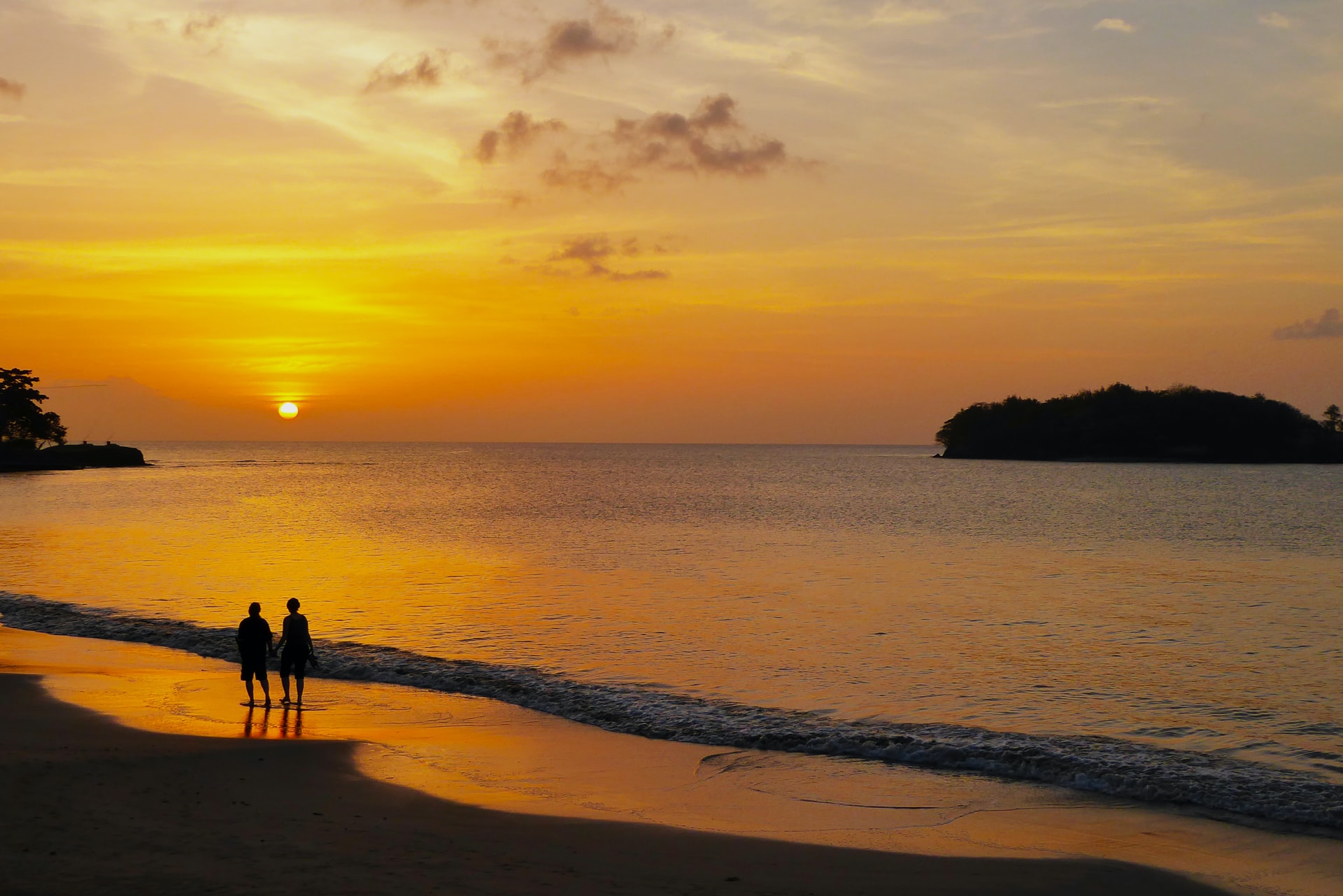 St. Lucia beach at sunset, a couple walks on the sand