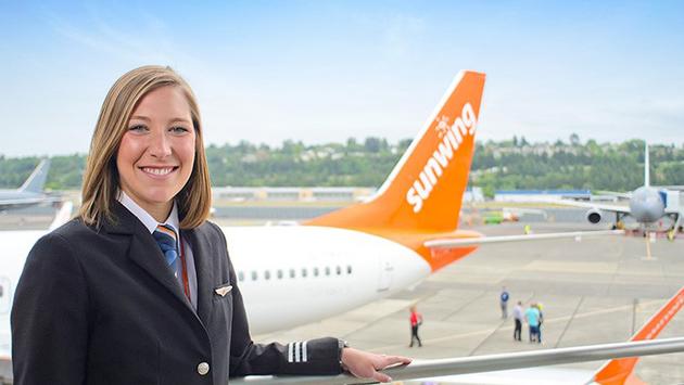 Sunwing flight attendant next to plane