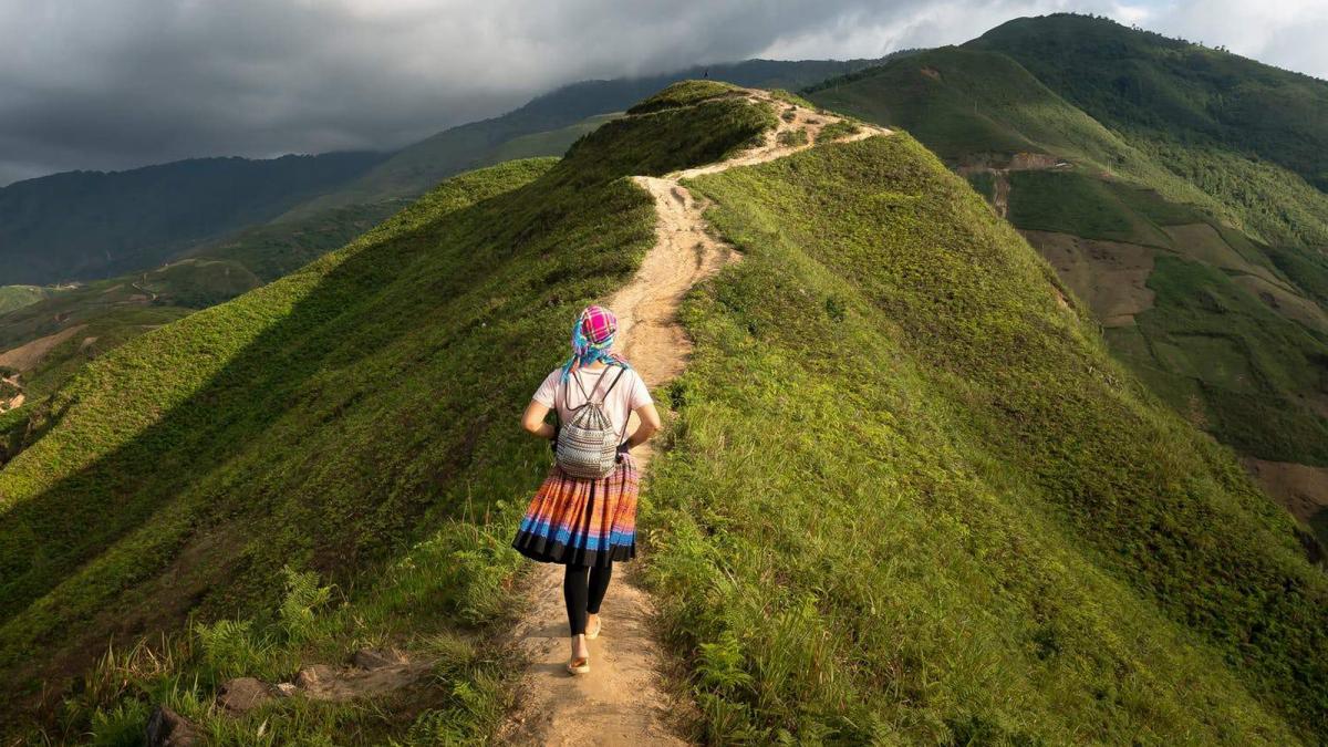 a woman walks on the top of a mountain