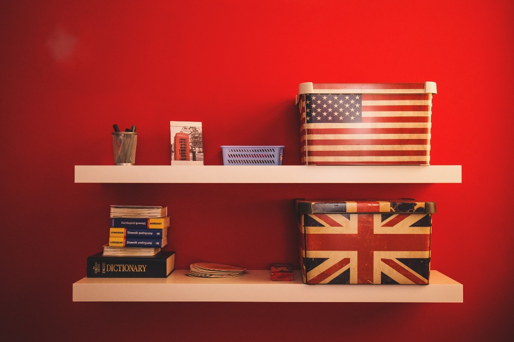 UK US suitcases on two shelves, other objects