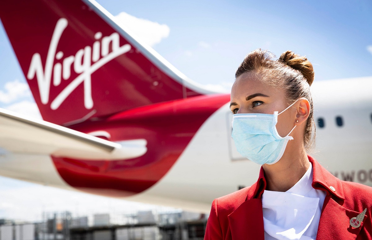 Virgin Atlantic plane tail and flight attendant wearing a face mask