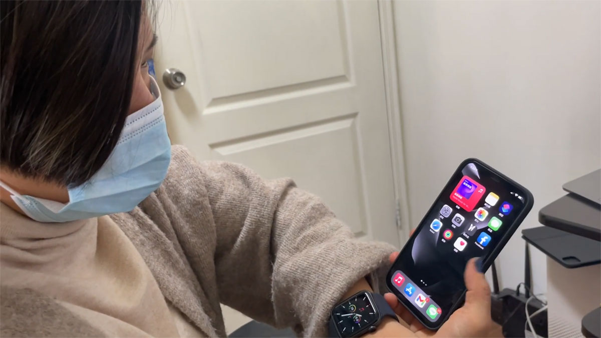 unblocking iPhone with mask on, a woman
