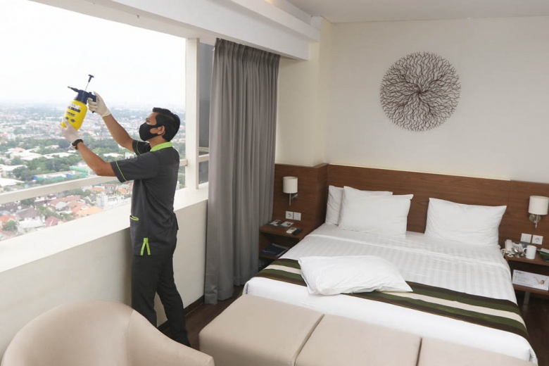 man cleaning hotel room window