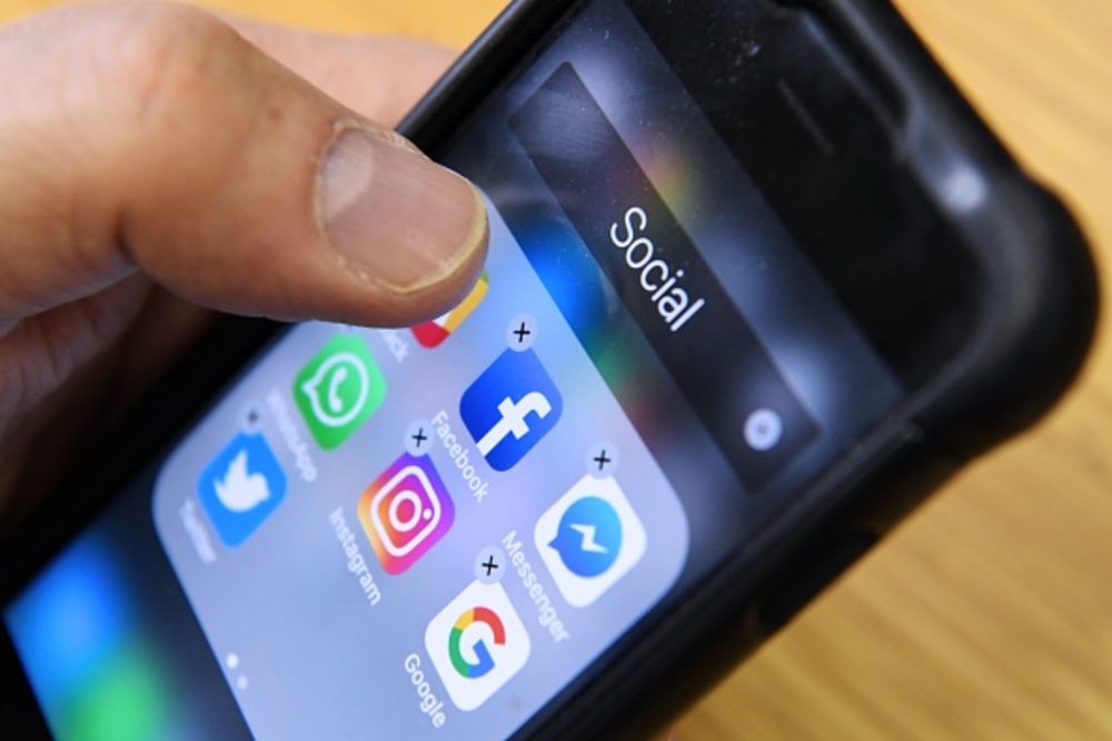 a hand scrolling social media on a phone