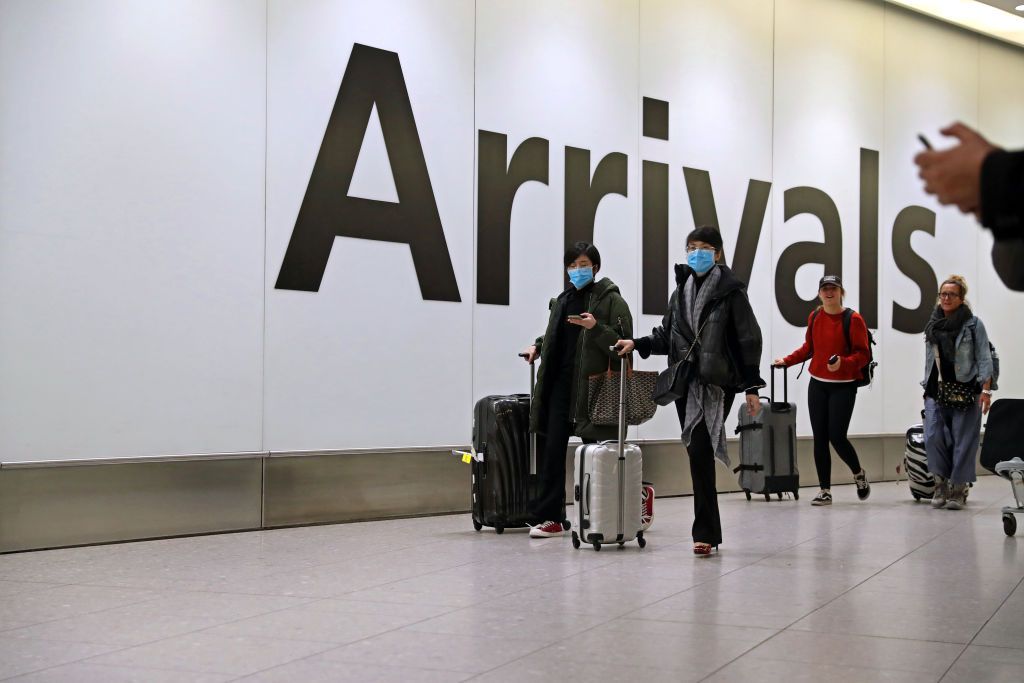 passengers with masks arriving at airport